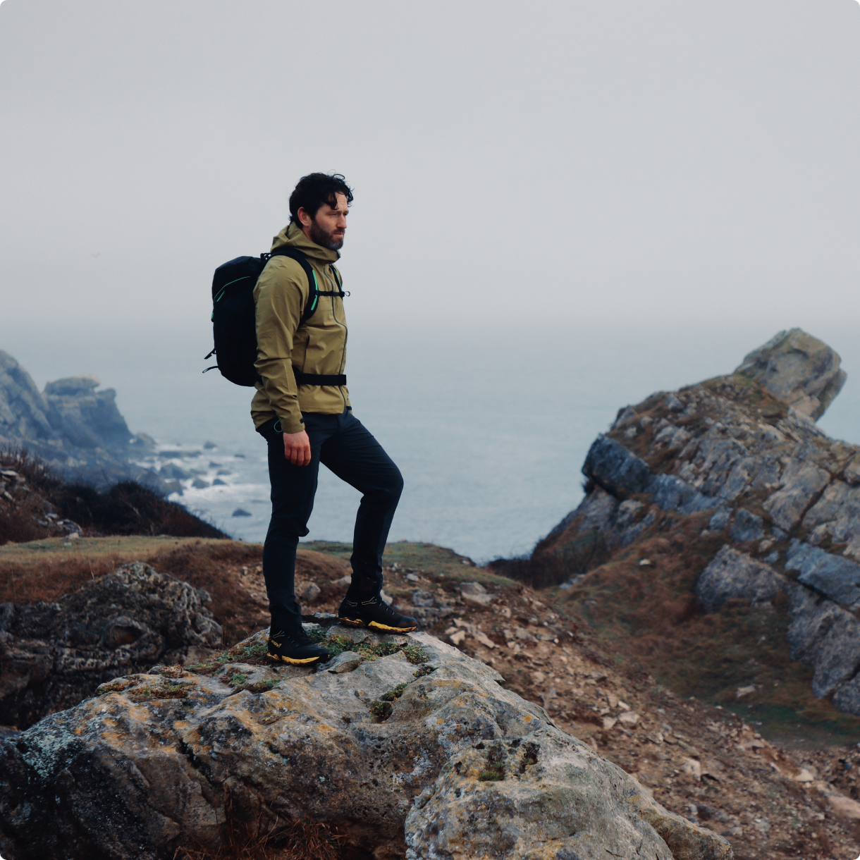 Hiker standing on a rock overlooking the sea