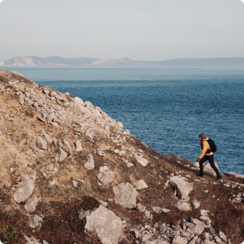 Woman walking along a rocky coastline