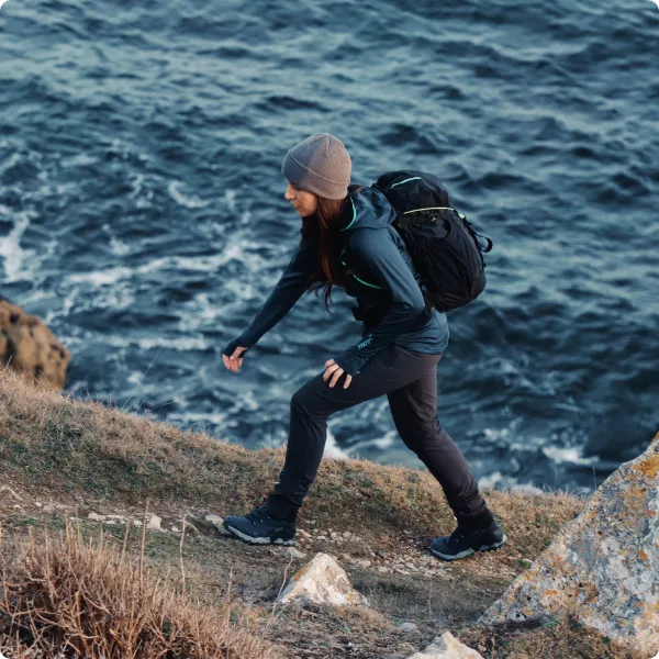 Woman hiking on a coastal path, wearing the ROCLITE PRO G 400 GTX V2 boots