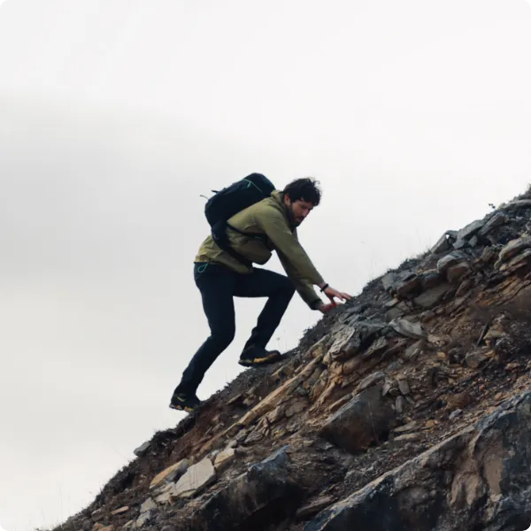 Man climbing up a rocky hill