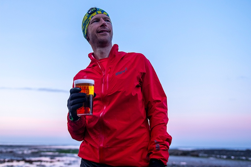 Damian at the finish in Robin Hood's Bay with a very well-deserved beer” width=